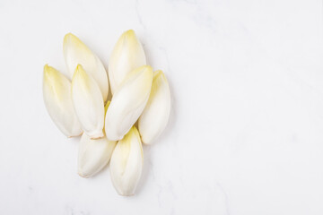 Fototapeta premium 1 kilo Raw chicory on a marble surface copy space right