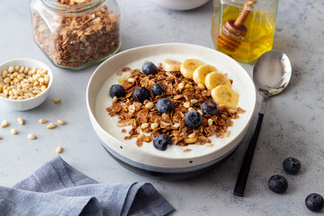 Granola with yogurt, blueberries, nuts, banana and honey. Muesli. Healthy eating. Vegetarian food.