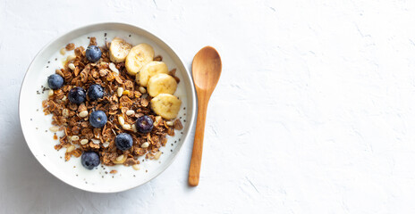 Granola with yogurt, blueberries, nuts, banana and honey. Muesli. Healthy eating. Vegetarian food.