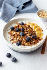 Granola with yogurt, blueberries, nuts, banana and honey. Muesli. Healthy eating. Vegetarian food.