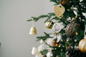 Christmas tree decorated with white and golden balls close up.