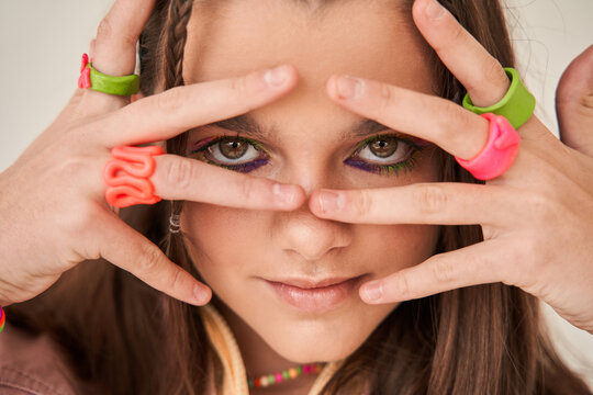 Cherry Girl With Brunette Hair Looking At The Camera Through Her Fingers While Posing