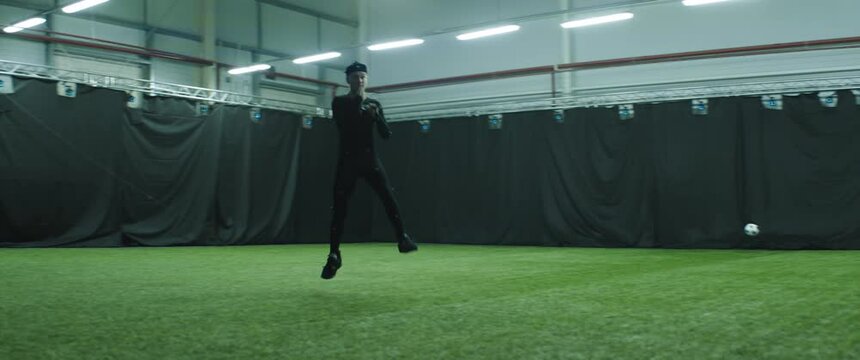 Soccer football player wearing motion capture suit performing kicks and tackles as game character. Motion capture is an unparalleled method for making animated characters move more realistically