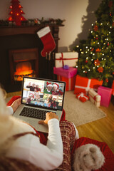 Naklejka na ściany i meble Santa claus making laptop christmas group video call with smiling caucasian family and friends