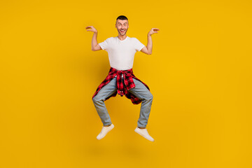 Full length body size photo man jumping fooling childish isolated bright yellow color background