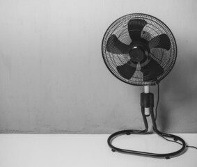 Fototapeta Black electric fan in room with gray walls obraz