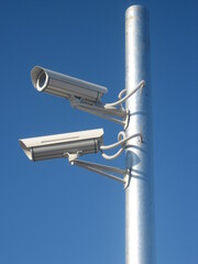 video surveillance camera mounted on a pole against the sky
