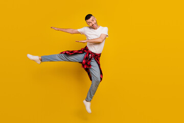 Fototapeta na wymiar Full length body size photo man jumping up dancing careless isolated vivid yellow color background