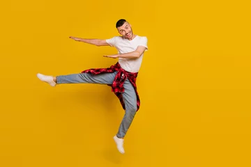 Keuken spatwand met foto Full length body size photo man jumping up dancing careless isolated vivid yellow color background © deagreez