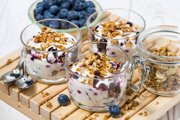 glasses with healthy dessert with blueberries, yogurt and muesli