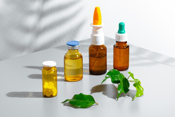 Herbal extracts in small bottles on gray background