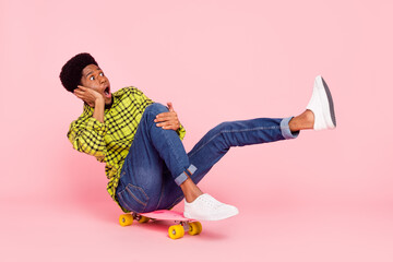 Full body photo of amazed excited afro american man ride longboard speed copyspace isolated on pink color background