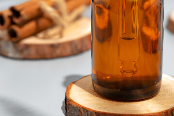 Amber glass bottle for cosmetics, natural medicine or essential oil on gray background