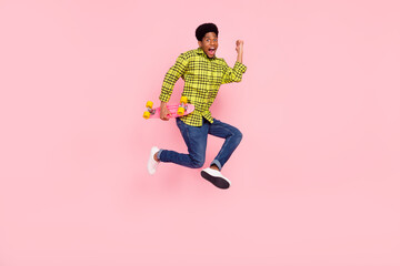 Fototapeta na wymiar Full size photo of excited afro american man longboard jump wear casual clothes win isolated on pink color background