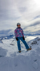 Fototapeta na wymiar Snowboarding girl standing on the top of a mountain in Moelltaler Gletscher, Austria, enjoying the view. Lots of snow in the mountains. Endless Alps chain. Winter wonderland. Calmness and happiness.
