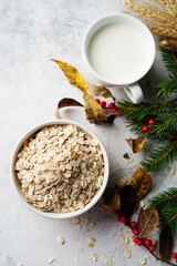Old fashioned rolled oats in a white bowl on holiday background, selective focus