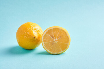 one limon with a cut lemon lie on a blue background