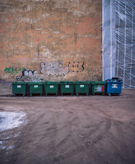 Many garbage bins for sorting waste standing in the yard