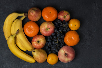 ripe juicy fresh fruits on dark background