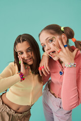 Teen besties standing at the fashionable poses and demonstrating vivd looks