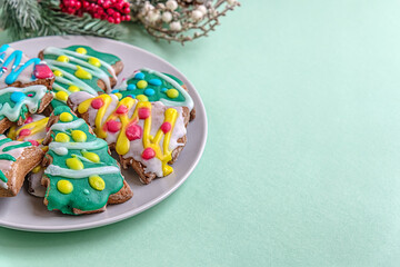 festive Christmass background of handmade Christmas gingerbread cookies in the shape of trees decorated with colorful glaze