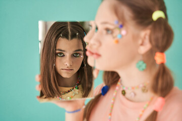 Caucasian brunette girl reflected at the mirror holding another female person