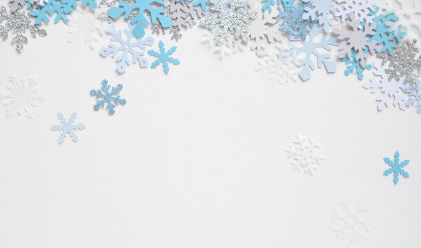 Copos de nieve cayendo en un fondo blanco texturado tela. Se puede usar como fondo de navidad.
