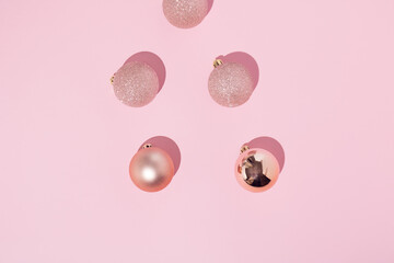 Pink christmas decoration balls with shadow on pastel pink background. Top view. Flat lay.