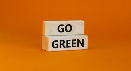 Time to go green ecology symbol. Concept words Go green on wooden blocks on a beautiful orange background. Business, ecology and go green concept. Copy space.