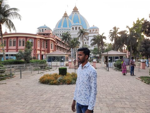 young boy standing front of iskcon temple in mayapur, tovp temple, mayapur temple.