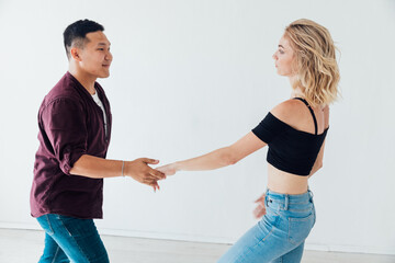 a man and a woman dance to the music of a paired dance of bachata in a white room