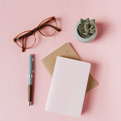 Carnets, stylo, lunettes et succulent sur fond rose pour l'inspiration d'écrire, faire des listes...