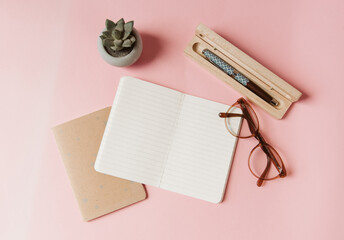 Carnet, stylo plume, lunettes et succulent sur fond rose pour trouver l'inspiration d'écrire, de...