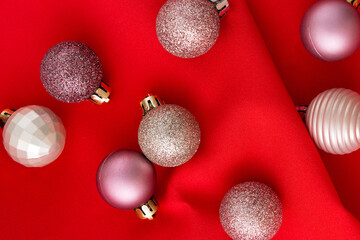 Christmas decoration with balls on a red background from crumpled fabric.