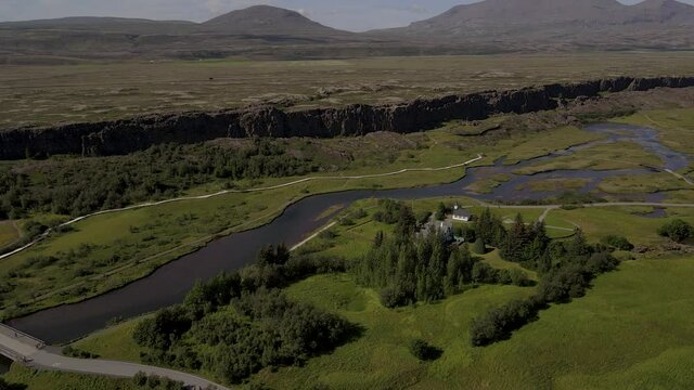 Cinematic aerial footage of Thingvellir national park, Iceland's parliament, the Thingvellir Church and the ruins of old stone shelters, hikes and lake in the golden circule