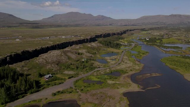 Cinematic aerial footage of Thingvellir national park, Iceland's parliament, the Thingvellir Church and the ruins of old stone shelters, hikes and lake in the golden circule