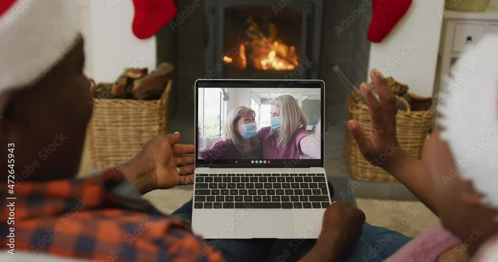 Canvas Prints African american couple with santa hats using laptop for christmas video call with family on screen