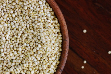 Quinoa seeds in wooden bowl closeup on brown wooden background with copy space. top view. Healthy food concept.