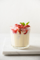 Layered strawberry trifle dessert cookie savoyardi, mascarpone and whipped cream on white background. Vertical orientation. Close up.