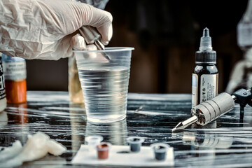 Professional tattooer working tattooing in tattoo studio