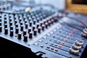 Mixing console close-up with a small depth of field in the background light.
