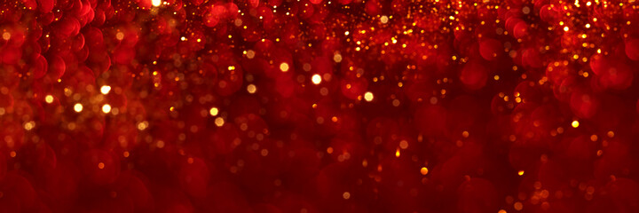 Red and golden sparkling glitter bokeh background, christmas texture. Holiday lights. Abstract defocused header. Wide screen wallpaper. Panoramic web banner with copy space for design