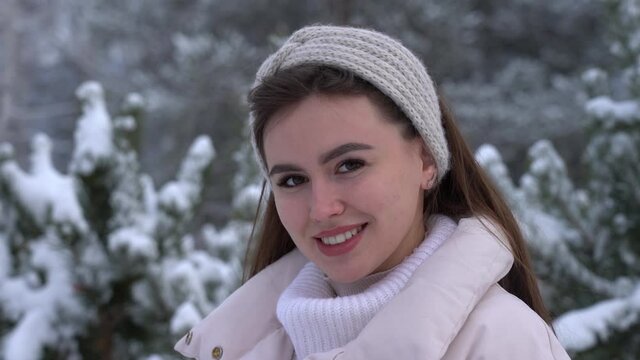Young attractive woman smiles in winter in the park