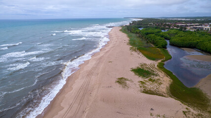 Aerial view of Imbassai beach, Bahia, Brazil. Beautiful beach in the northeast with a river and palm trees.