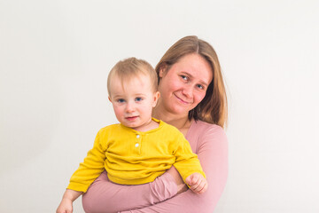 One year and three month boy in mother's arms on white background