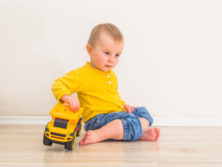One year three months old boy is sitting and playing with a toy truck © Crazy nook