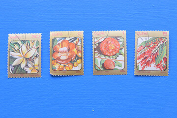 postage stamps isolated on a wooden background with the image of flowers, background, top view