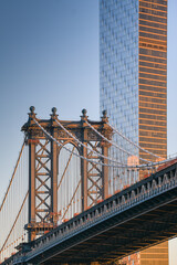 Travel to New York. The skyline of Manhattan photographed during a summer sunrise, view to Manhattan Bridge. Landmarks of United States of America. Skyscraper office buildings.