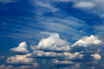 Dark gray cumulus clouds are photographed against a blue sky. Cloudy weather. Dull.