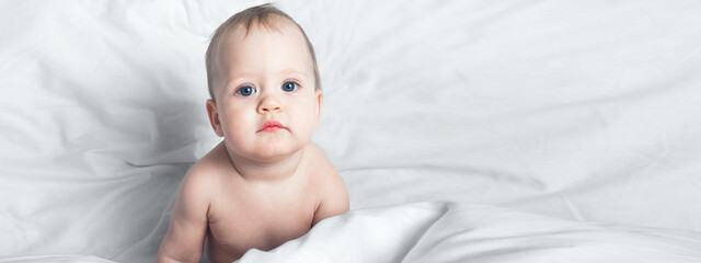 Banner. Child 1 year old on bed close-up..